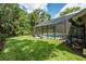Enclosed pool with seating, outdoor space, and lawn surrounded by lush greenery at 20 Twelve Oaks Trl, Ormond Beach, FL 32174
