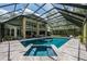 Large screened-in pool with a spa and ample patio space surrounded by beautiful landscaping at 20 Twelve Oaks Trl, Ormond Beach, FL 32174
