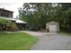 Spacious backyard with detached garage and outbuilding surrounded by lush greenery and a well-manicured lawn at 2101 S Goldenrod Rd, Orlando, FL 32822
