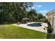 Lush backyard featuring a private pool, landscaped lawn, and an outdoor dining area at 2122 Palm Crest Dr, Apopka, FL 32712