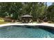 Beautiful in-ground pool with an outdoor gazebo surrounded by lush landscaping at 2122 Palm Crest Dr, Apopka, FL 32712