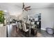Dining area with a long table, hardwood floors, statement fan and views into the living spaces at 2122 Palm Crest Dr, Apopka, FL 32712