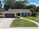 Charming home featuring a well-kept lawn, driveway, attached garage, and mature landscaping at 2122 Palm Crest Dr, Apopka, FL 32712