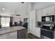 Modern kitchen featuring granite countertops, stainless steel appliances, white cabinets and an open layout to the living room at 2122 Palm Crest Dr, Apopka, FL 32712