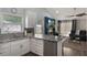 Bright kitchen featuring stainless steel appliances, white cabinets, granite countertops, and an open view to the living area at 2122 Palm Crest Dr, Apopka, FL 32712