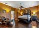 Well-lit bedroom with dark wood floors, a four-poster bed, and warm-toned walls at 2538 Carter Grove Cir, Windermere, FL 34786