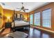 Well-lit bedroom with dark wood floors, a four-poster bed, and warm-toned walls at 2538 Carter Grove Cir, Windermere, FL 34786