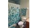 Neat bathroom featuring a leafy shower curtain and tropical-themed towels for a relaxing ambiance at 2545 Old Kent Cir, Kissimmee, FL 34758