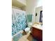 Well-lit bathroom showcasing a shower with a decorative curtain and complementing tropical-themed towels at 2545 Old Kent Cir, Kissimmee, FL 34758