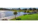 A serene view of a large pond surrounded by lush greenery and walking trail at 2545 Old Kent Cir, Kissimmee, FL 34758