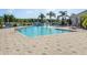 Enjoy the community pool with a water feature, sun loungers, and tropical palms at 2545 Old Kent Cir, Kissimmee, FL 34758