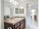 Bathroom with vanity, featuring dark cabinets, granite countertops, and framed mirror at 2724 Shelby Ruth Pl, St Cloud, FL 34769