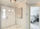 Bright foyer featuring marble floors, a white front door, and a view into the bedroom with a metal bed frame at 2724 Shelby Ruth Pl, St Cloud, FL 34769