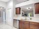 Kitchen area with dark wood cabinets, stainless steel appliances, and a view to the living room at 2724 Shelby Ruth Pl, St Cloud, FL 34769