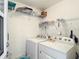 Clean, white laundry room with modern washer and dryer and ample storage shelving at 2724 Shelby Ruth Pl, St Cloud, FL 34769