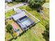 Aerial view of a home with a screened pool, playground, solar panel roof, and a spacious backyard at 2832 Buccaneer Dr, Winter Park, FL 32792