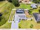 Aerial view of a fenced home with solar panels, screened pool, playground, and well-manicured lawn at 2832 Buccaneer Dr, Winter Park, FL 32792