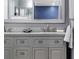Bathroom with dual sinks, grey cabinets, and a large framed mirror at 2832 Buccaneer Dr, Winter Park, FL 32792