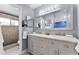 Well-lit bathroom with double sink vanity, large mirror, and a walk-in shower at 2832 Buccaneer Dr, Winter Park, FL 32792