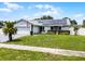 Inviting single-story house with a gray roof, solar panels, two-car garage, and well-kept front yard at 2832 Buccaneer Dr, Winter Park, FL 32792