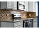 Close-up of stainless steel oven and granite counters, tile backsplash and ample cabinet space at 2832 Buccaneer Dr, Winter Park, FL 32792