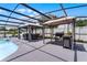 Screened-in pool area, including lounge chairs, tables with chairs, and a built-in grill area at 2832 Buccaneer Dr, Winter Park, FL 32792