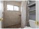 Tiled walk-in shower with window, shower curtain, and a convenient toilet at 2832 Buccaneer Dr, Winter Park, FL 32792