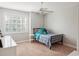 Cozy bedroom with a bed, bedside table, ceiling fan, and large window with plantation shutters at 2880 Old Castle Dr, Winter Park, FL 32792