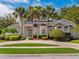 Stunning home with elegant architectural details, mature landscaping, and palm trees at 2880 Old Castle Dr, Winter Park, FL 32792