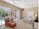 Bright main bedroom with a view of the pool, chair, and an attached bathroom at 2880 Old Castle Dr, Winter Park, FL 32792