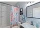 The renovated bathroom features subway tile, floral shower curtain, and updated black fixtures at 298 Clydesdale Cir, Sanford, FL 32773