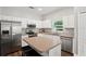Modern kitchen with stainless steel appliances, white cabinets, and an island with seating at 298 Clydesdale Cir, Sanford, FL 32773