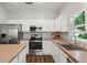 Bright kitchen featuring stainless steel appliances, white cabinets, and a large window at 298 Clydesdale Cir, Sanford, FL 32773