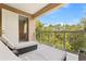 Relaxing balcony with comfortable lounge chairs and clear glass railings overlooking lush trees and sky at 3149 Brasilia Ave, Kissimmee, FL 34747