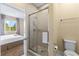 Clean bathroom with a glass-enclosed shower and view to a bedroom with large bright window at 3149 Brasilia Ave, Kissimmee, FL 34747