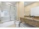 Bright bathroom features a granite countertop and a shower/tub combo with sliding glass doors at 3149 Brasilia Ave, Kissimmee, FL 34747