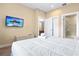 Well-lit bedroom featuring a large flat screen television and a doorway to the bathroom at 3149 Brasilia Ave, Kissimmee, FL 34747