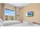 Comfortable bedroom with two twin beds, TV, and a bright window with view of the neighborhood at 3149 Brasilia Ave, Kissimmee, FL 34747