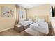 Neutral bedroom features two beds with upholstered headboards, ottomans, and a whimsical bicycle print at 3149 Brasilia Ave, Kissimmee, FL 34747