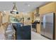 Modern kitchen featuring an island with seating, stainless steel appliances, and natural wood cabinets at 3149 Brasilia Ave, Kissimmee, FL 34747