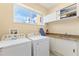 Laundry room featuring a washer, dryer, storage cabinets, countertop, and window with a view at 3149 Brasilia Ave, Kissimmee, FL 34747