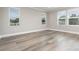 Bright bedroom with plank flooring boasts natural light from three large windows at 31792 Broadwater Ave, Leesburg, FL 34748