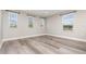 Bright bedroom featuring three windows and wood-look floors, offering ample natural light at 31792 Broadwater Ave, Leesburg, FL 34748