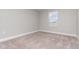 Neutral bedroom featuring a window and neutral carpet at 31792 Broadwater Ave, Leesburg, FL 34748