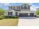 Charming two-story home with a three-car garage, manicured lawn and neutral-toned exterior at 31792 Broadwater Ave, Leesburg, FL 34748