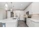 Modern kitchen features white cabinets, stainless steel appliances, and an island with quartz countertop at 31792 Broadwater Ave, Leesburg, FL 34748