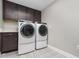Well-lit laundry room features modern appliances, attractive cabinets and decorative tile flooring at 31792 Broadwater Ave, Leesburg, FL 34748