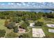 An aerial view displays a park with a playground, firepit, basketball and volleyball courts surrounded by mature trees at 3349 Sagebrush St, Harmony, FL 34773