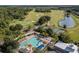An aerial view shows a pool, tennis courts and golf course surrounded by lush tropical landscape and mature trees at 3349 Sagebrush St, Harmony, FL 34773