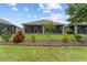 Well-maintained backyard with lush green grass, colorful plants, and a screened-in porch at 3349 Sagebrush St, Harmony, FL 34773